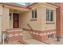 Close up view of front entryway with brick accents and tiled stairs at 60 Yarrow St, Lakewood, CO 80226