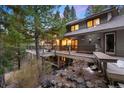 Spacious back deck with outdoor seating and a view of the forest at 3816 Spring Valley Trl, Evergreen, CO 80439