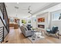 Bright, open concept living room featuring hardwood floors, fireplace and modern decor seamlessly flowing to the kitchen at 964 Quitman St, Denver, CO 80204