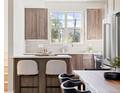 Modern kitchen with wooden cabinets, stainless steel appliances, and a breakfast bar with seating at 2828 N Federal Blvd, Denver, CO 80211