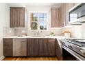 Well-lit kitchen with stainless steel appliances, wood cabinets, and a white tile backsplash at 2828 N Federal Blvd, Denver, CO 80211
