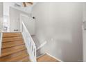 Bright and airy staircase with wood steps and white railings, leading to the upper level at 6183 Xavier St, Arvada, CO 80003
