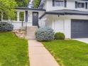 Close-up of the home's entrance featuring a well-manicured lawn and updated stairs at 3793 S Sebring Ct, Denver, CO 80237