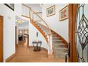 Elegant foyer with a curved staircase, light hardwood floors, and decorative artwork at 1437 Cassin Ct, Boulder, CO 80303