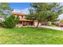 Beautiful home with a spacious lawn and mature trees creating a serene and inviting atmosphere at 18434 E Belleview Ln, Centennial, CO 80015