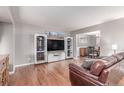 Inviting living room featuring hardwood floors, a large TV, and a stylish entertainment center at 18434 E Belleview Ln, Centennial, CO 80015