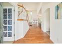 Inviting foyer with hardwood floors, a decorative door, and an open staircase leading to the upper level at 1477 Serene Dr, Erie, CO 80516