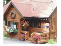 Inviting front porch with flower pots and hanging baskets, plus a warm, welcoming entrance to the home at 9530 Aspen Ln, Conifer, CO 80433
