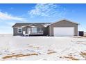 Gray ranch home with white garage door and snowy yard at 9 Timberlake Ct, Byers, CO 80103