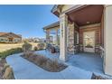 Inviting front porch with stone columns and seating area at 12625 at 12625 Madison Way, Thornton, CO 80241
