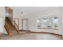 Spacious living room with hardwood floors and large windows, offering ample natural light and an airy feel at 16420 Martingale Dr, Parker, CO 80134