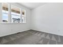 Bright bedroom with large windows providing great natural light and gray patterned carpet at 564 Penn Rd, Elizabeth, CO 80107