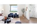 Sunlit living room with contemporary furnishings and a view of lush greenery at 385 East St, Louisville, CO 80027