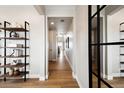Bright hallway featuring wood floors, modern shelving, and an abundance of natural light at 8958 Whiteclover St, Littleton, CO 80125