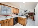 Bright kitchen with light wood cabinets, white appliances, and an island, with access to the adjacent dining room at 3245 S Nucla St, Aurora, CO 80013