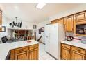 Open kitchen with light wood cabinets, white appliances, and access to the dining room and living area at 3245 S Nucla St, Aurora, CO 80013