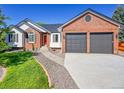 Charming two-story brick home featuring manicured front yard and two-car garage at 7809 S Flower St, Littleton, CO 80128