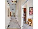 Inviting hallway with neutral colors, a decorative mirror and an open doorway to an office space at 7809 S Flower St, Littleton, CO 80128