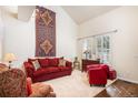 Comfortable living room featuring a high ceiling, large decorative wall hanging, and ample seating at 8300 Fairmount Dr # M103, Denver, CO 80247