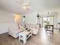 Spacious living room boasts modern lighting, stylish seating, and access to the dining area at 10895 Fairfax Way, Thornton, CO 80233