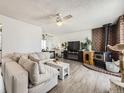 Bright living room featuring a cozy fireplace, modern ceiling fan, and comfortable seating area at 10895 Fairfax Way, Thornton, CO 80233