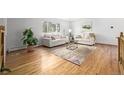 Bright living room featuring hardwood floors, couches, rug, and a plant at 833 Applewood Dr, Lafayette, CO 80026