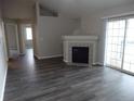 Bright living room with wood-look flooring, fireplace, and sliding glass doors at 3271 E 103Rd Pl # 1308, Thornton, CO 80229
