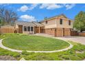 Charming two-story home with manicured lawn, showcasing classic architecture and an attached two-car garage at 7285 S Yukon Ct, Littleton, CO 80128