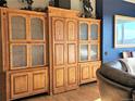 Custom built-in shelving unit with glass doors and wood finish with adjacent living room furniture at 83 Wilderness Cornerstone Rd, Evergreen, CO 80439