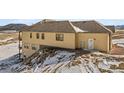 Exterior view of a two-story house with a tan exterior and snow on the ground at 5320 Dual Rey Pt, Sedalia, CO 80135