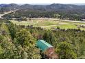 A home sits amongst trees with a scenic mountain view at 8386 S Davco Dr, Morrison, CO 80465