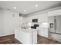 Bright white kitchen featuring an island, modern appliances, and wood-look flooring at 485 Interlocken Blvd # 209, Broomfield, CO 80021
