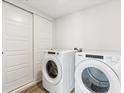 Bright laundry room features white washer and dryer set, as well as white sliding doors at 485 Interlocken Blvd # 209, Broomfield, CO 80021