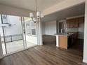 Modern kitchen with an island, stainless appliances, and hardwood floors, bathed in natural light from sliding glass doors at 7243 Prairie Sage Ln, Littleton, CO 80125