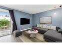 Stylish living room with sliding glass doors, modern furniture, and neutral color palette at 13993 E Jewell Ave, Aurora, CO 80012