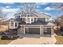 Stunning two-story home with a meticulously kept lawn, gray exterior, stone accents, and a three-car garage at 538 Fairfield Ln, Louisville, CO 80027