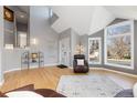Bright living room featuring vaulted ceilings, large windows, light gray walls, and beautiful hardwood flooring at 538 Fairfield Ln, Louisville, CO 80027