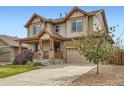 Charming two-story house boasting a stone-accented garage and welcoming covered front porch at 350 N Langdale Ct, Aurora, CO 80018