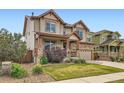 Attractive two-story home featuring a stone garage facade, covered porch, and manicured landscaping at 350 N Langdale Ct, Aurora, CO 80018