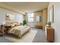 Comfortable bedroom with a large window offering city views and a neutral color scheme at 1301 Speer Blvd # 1008, Denver, CO 80204
