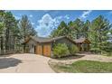 Exterior of home featuring three-car garage, natural landscaping, and a covered porch at 2231 Meadow Green Cir, Franktown, CO 80116