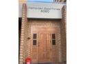 Exterior entrance featuring brick facade and an ornate wooden door with decorative carvings and glass panels at 8060 E Girard Ave # 504, Denver, CO 80231