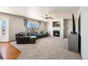 Cozy living room featuring a fireplace, large windows, and a comfortable sectional sofa at 9799 Falcon Ln, Littleton, CO 80125