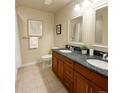 Bathroom featuring a double vanity with granite countertops and a tiled floor at 1975 Grant St # 501, Denver, CO 80203