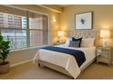 Cozy bedroom with a plush bed, large window overlooking the city, and mirrored nightstands at 1975 Grant St # 501, Denver, CO 80203