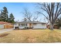 Wide view of white brick home with welcoming front door and bay window, surrounded by a well maintained yard at 2570 Bell Ct, Lakewood, CO 80215