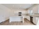 Modern kitchen with white cabinets, stainless steel appliances, and a spacious island at 15276 Fillmore St, Thornton, CO 80602