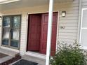 Front door with beige siding and open front door with storm door at 1967 S Oakland Way, Aurora, CO 80014