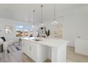 Open kitchen and living space with an island, pendant lighting, and modern decor at 6971 E Lowry Blvd, Denver, CO 80230