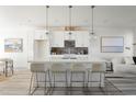 Modern kitchen with a large island, pendant lighting, and stainless steel appliances at 6971 E Lowry Blvd, Denver, CO 80230
